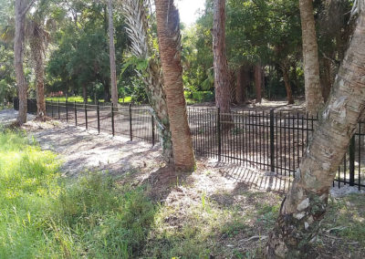 A fenced in area with trees and bushes.