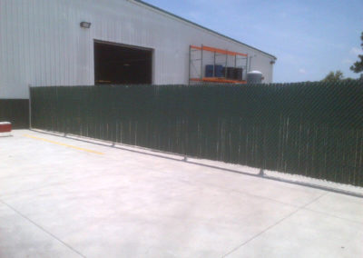 A green fence in front of a building.