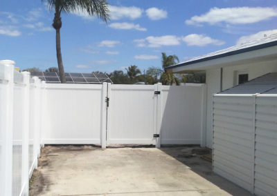 A house with white walls and white vinyl fence