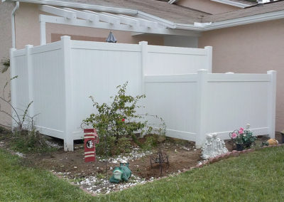 A white vinyl fence with a pink flower at the side