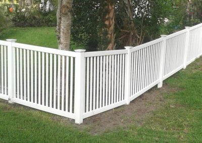 A white picket fence in a yard.