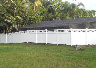 A white fence with a lattice in the yard.