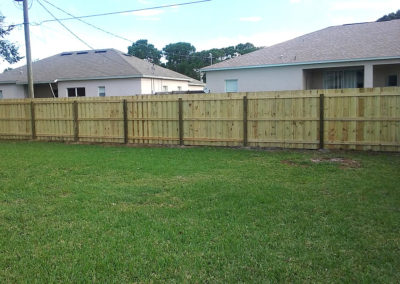 A wooden fence in the backyard of a house.